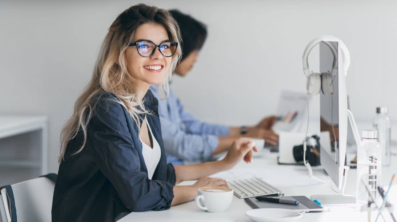 Picture of young blond Caucasian woman working on computer to create content for buyer's journey